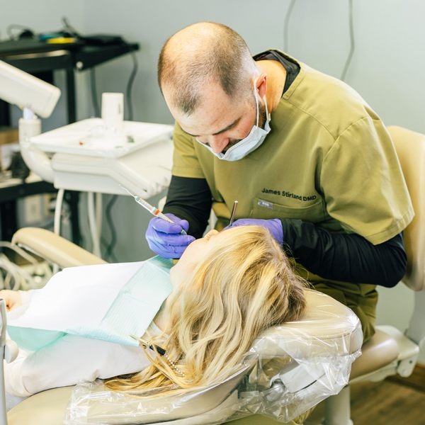 Dr. James Stirland with his patient in a dental chair